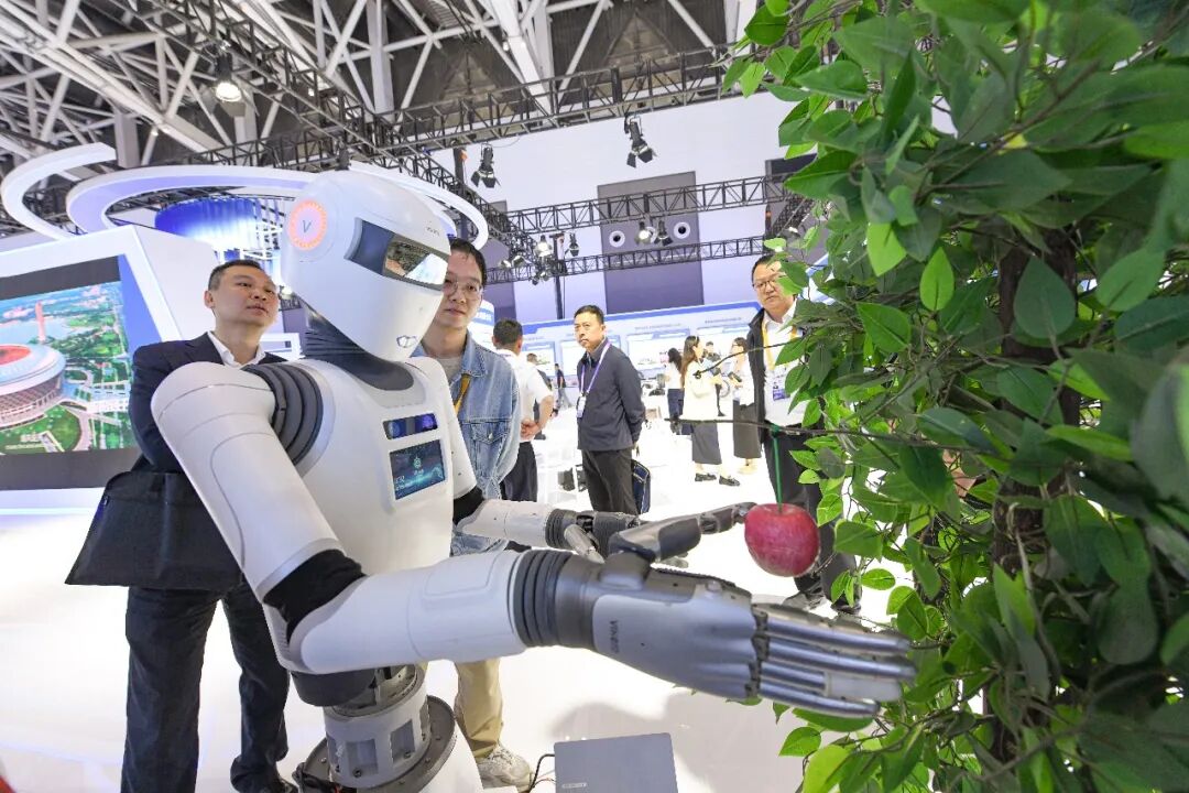 第十届丝博会上工作人员展示机器人现场摘苹果（资料图片）。